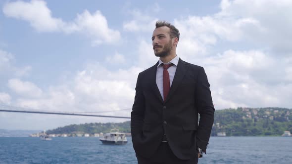 Thoughtful man stands by the sea.