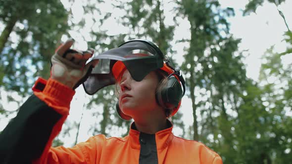Portrait of a Young Female Logger Standing in the Forest Woman Specialist in Protective Gear Opens