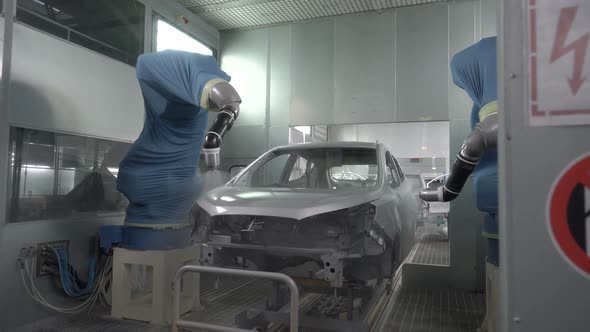 Robotic Arms Spray Painting a Vehicle Body at a Car Manufacturing Factory