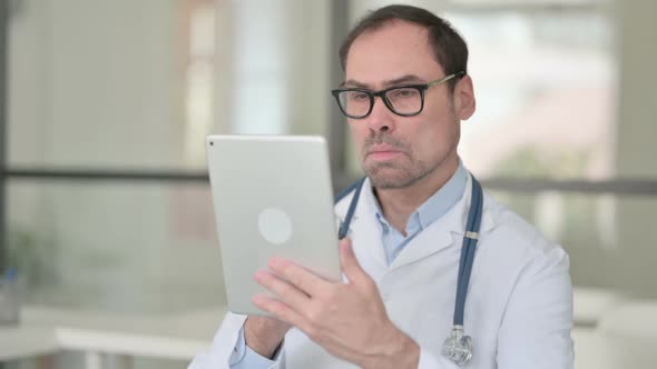 Middle Aged Doctor Using Digital Tablet