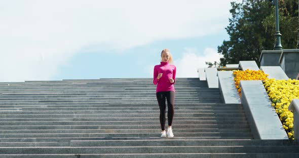 Young Blonde Woman Running on Stairs in City Park, Practicing Morning Cardio Workout, Free Space