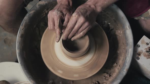 Potter Shapes the Clay Product with Pottery Tools on the Potter's Wheel Top View Toned Cinematic