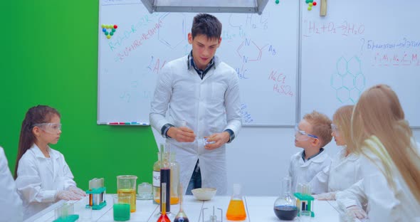 Pupils and Teacher Watching Experiment in Science Class