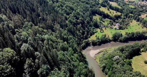 Aerial View Of The  Aries River Surrounded With Green Forest On Sunny Day In Romania.