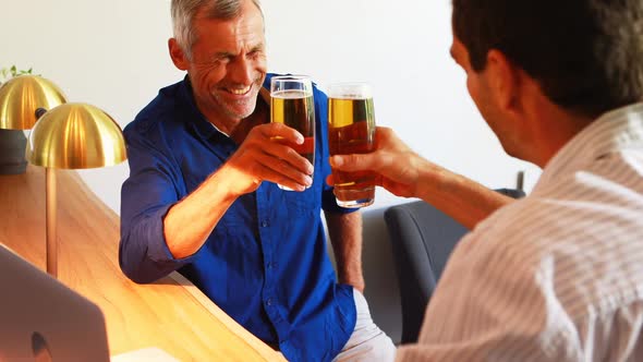 Two men toasting glasses of beer