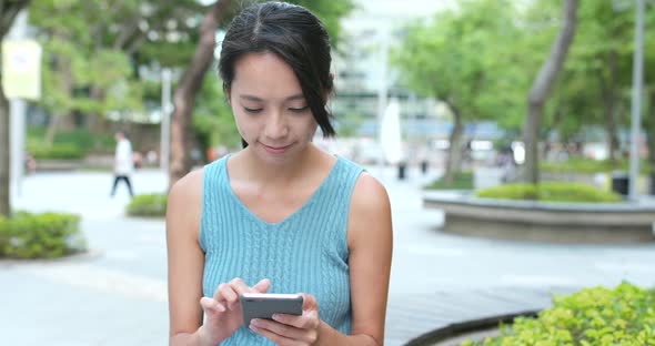 Young Woman use of mobile phone in the park