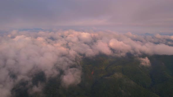 4K Flying through the clouds above mountain tops