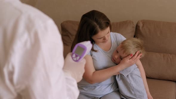 A Doctor Examines a Family with Symptoms of Coronavirus at Home