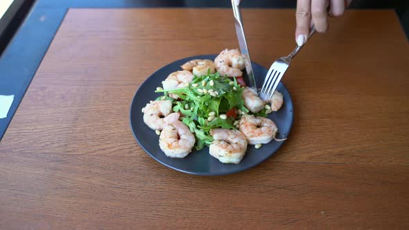 Young Woman at Restaurant Eating Shrimp Salad