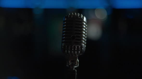 Closeup Acoustic Microphone with Stage Lights Turning Off at Background