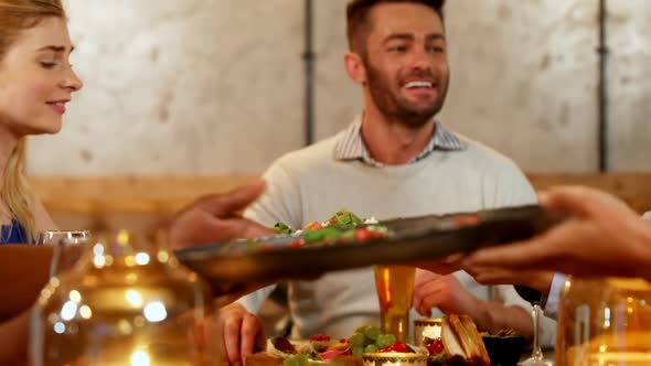 Happy friends offering food to each other on dinner table 4K 4k