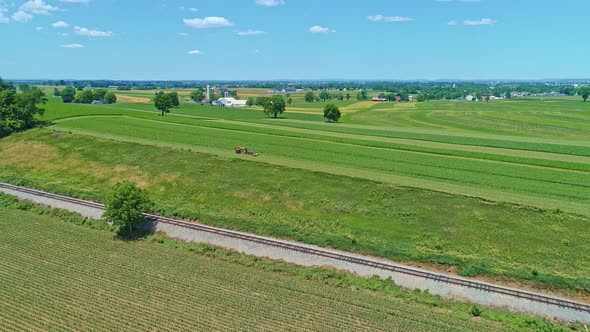 Aerial View of an Amish Farmer with Three Horses Harvesting His Crops