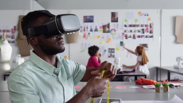 Mixed race man wearing VR headset in fashion office