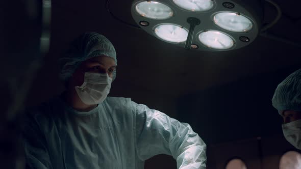 Woman Surgeon Performing Operation in Hospital Ward