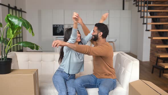 Young Indian Couple Happy to Buy an Apartment Sitting in New Modern Apartment with Keys