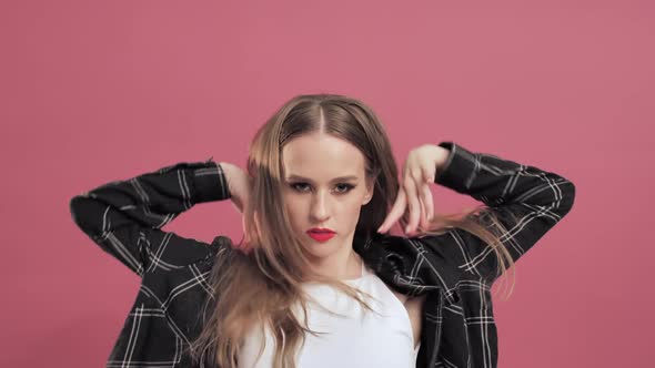 Young Teenage Girl with Long Hair Dancing and Having Fun on Rose Background