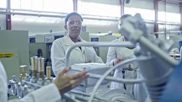 Experienced Female Engineers Discussing Factory Equipment