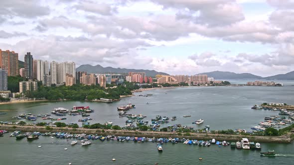 Aerial view of the typhoon shelter with boats and vessels and many residential buildings on the 2 si