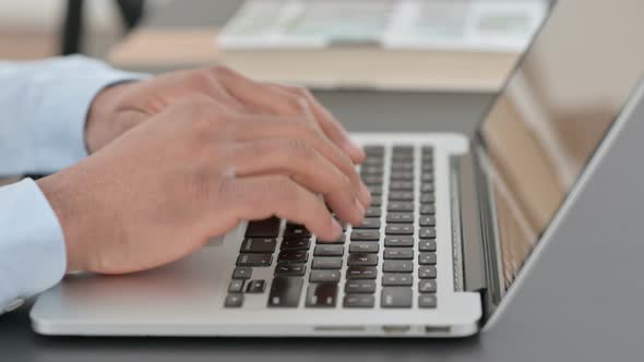 African Man Hands Typing on Laptop Close Up