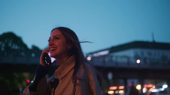 Young woman talking on the phone while walking