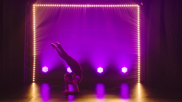 A Flexible Professional Female Athlete Performs Complex Acrobatic Elements of Rhythmic Gymnastics