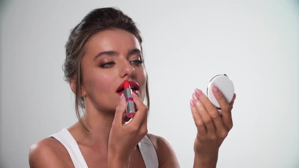 Lips Makeup. Beautiful Woman Applying Red Lipstick On Lip
