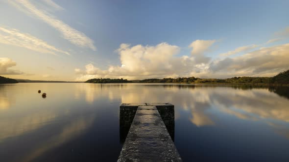 Time lapse of a concrete lake pier in rural Ireland during sunset evening.