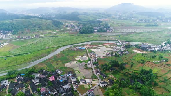 Aerial View of Rural Village Surrounded By Green Terraced Rice Field Farms in South of China