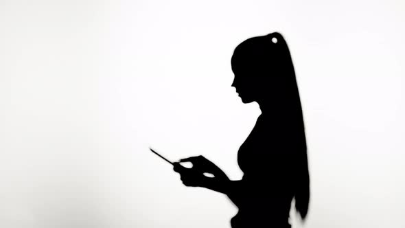 Shadow of Woman Using Gadget Tablet Closeup Silhouette of Female Person Typing on Touch Screen Pad