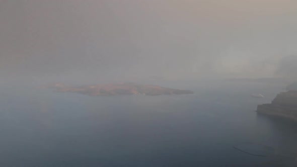 Time Lapse shot of a foggy summer morning, of the Santorini Caldera, with the volcano island visible