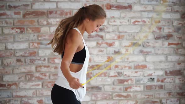 A Woman in Good Physical Shape Jumps on Rope to Strengthen the Muscles in Tonus