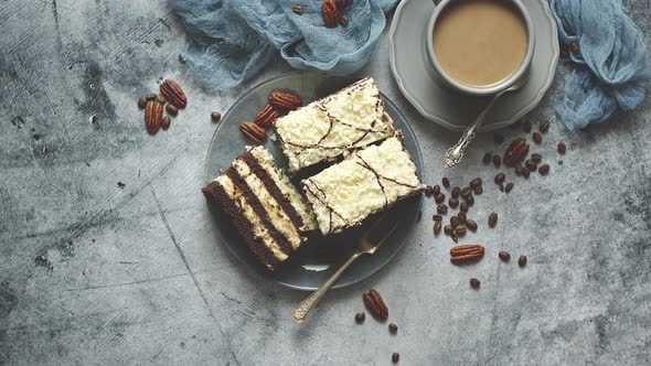 Tasty Layered Cake Sprinkled with White Chocolate. Served with Cup of Coffee on a Gray Concrete