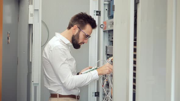 Network Engineer Working In Server Room.It Specialist On Computer Console In Server Room Data Center