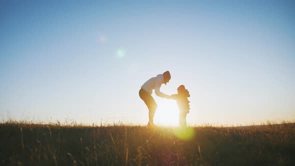 Mother and Little Son Playing on Meadow