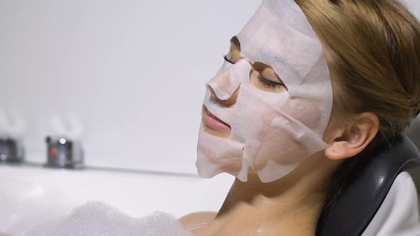 Beautiful Female Applying Face Mask Enjoying Warm Bath, Wellness Procedures, Spa