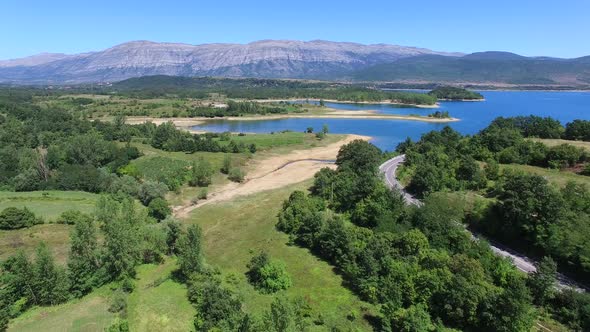 Flying above green environment of artificial lake Peruca, Croatia