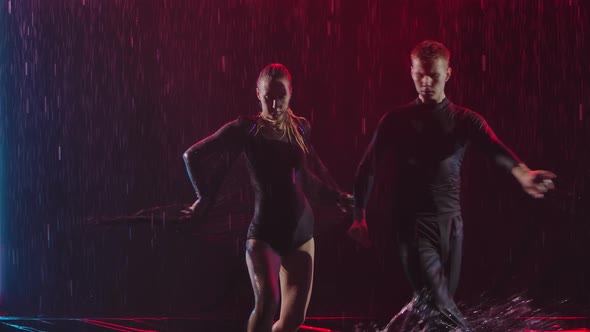 Dance Element From the Jive. A Couple of Ballroom Dancers in the Rain in a Smoky Studio. Slow Motion