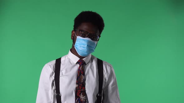 Portrait of Young African American Man in Medical Mask Looking Into Camera Removing Mask and Sighing