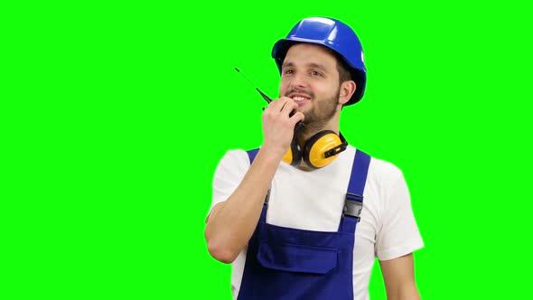 Foreman Speaks in a Walkie Talkie To the Colleagues. Green Screen