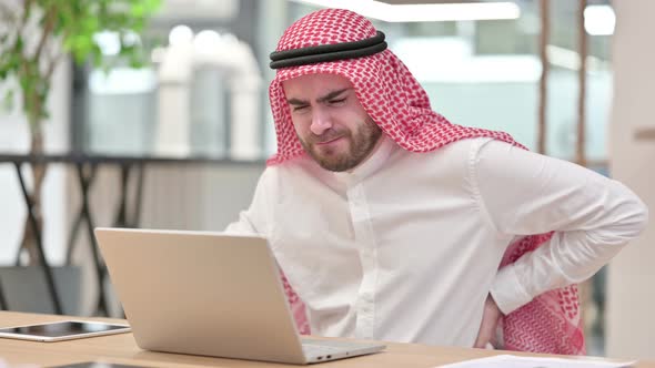 Tired Arab Businessman with Laptop Having Back Pain in Office 