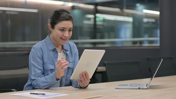 Successful Indian Woman Celebrating on Tablet at Work