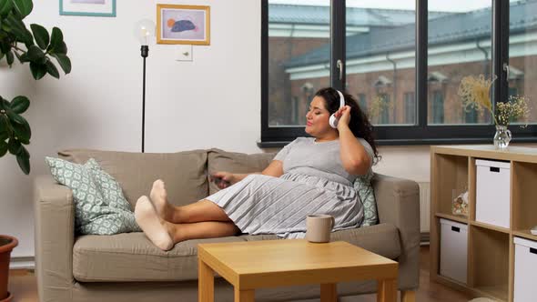 Woman in Headphones Listens To Music on Smartphone