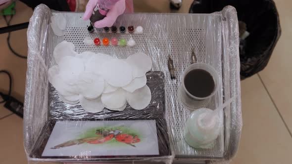 A Tattoo Master Pours Multicolored Ink Into Containers Before Applying a Tattoo