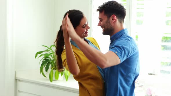 Happy couple dancing together in the kitchen