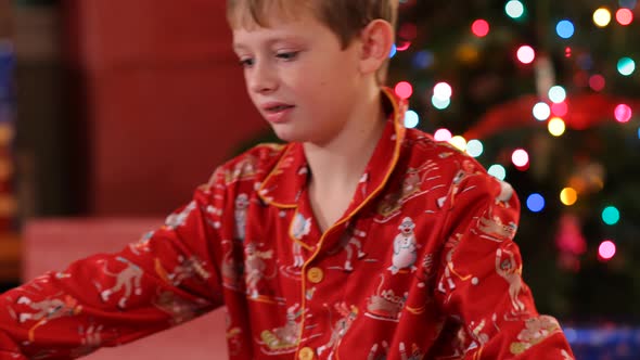 Boy tearing paper off Christmas gift