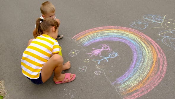 Children Draw with Chalk on the Asphalt