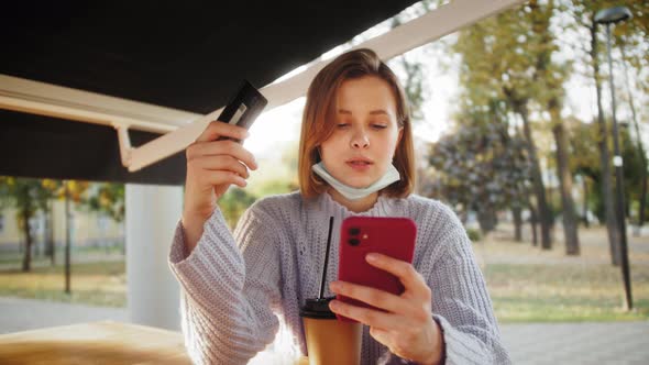 Woman shopping online on a sunny day with credit card. Online banking with smart phone. Easy pay.