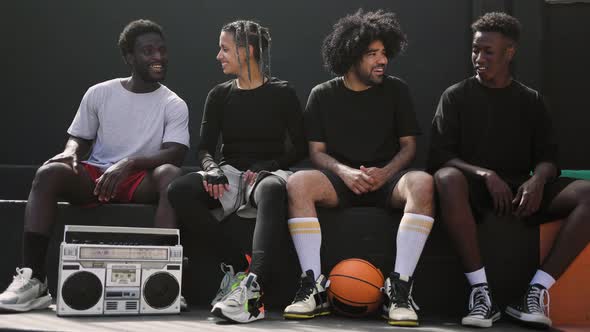 Young multiracial people having fun listening music with vintage boombox outdoor