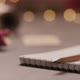 Notepad with Pencil on Walnut Wood Table with Christmas Lights on Background - VideoHive Item for Sale