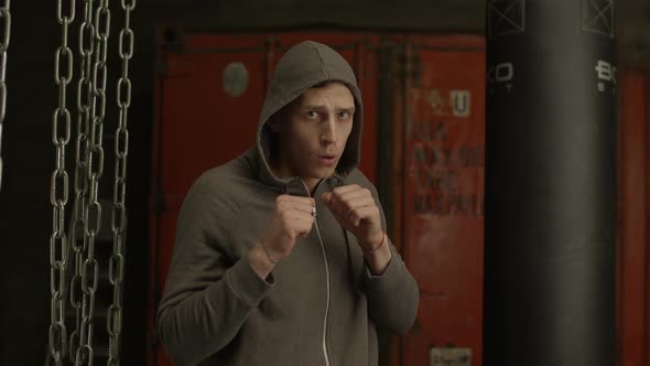 Boxer in Hoodie Throwing Punches Towards Camera